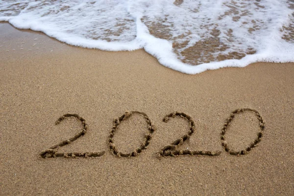 Anno 2020 scritto sulla spiaggia di sabbia caraibica con onde marine  . — Foto Stock