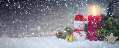 Christmas kırmızı dekorasyonu ile ilk Advent mum ve kardan adam ile arka plan.