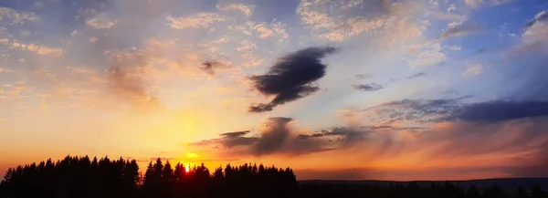 Farbenfroher dramatischer Sonnenuntergang mit großen Wolken und Bäumen. — Stockfoto