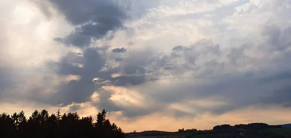 Farbenfroher dramatischer Sonnenuntergang mit großen Wolken und Bäumen. — Stockfoto