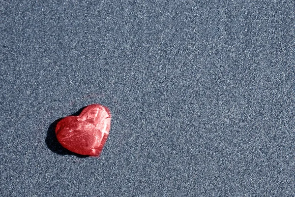 心の形をした赤い石は砂の上にある. — ストック写真