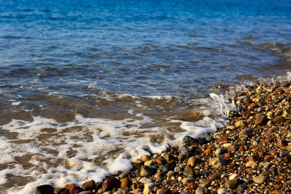 Onde di lavaggio sulla spiaggia di ghiaia, macro shot. — Foto Stock