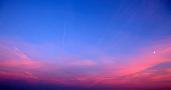 Pôr do sol com nuvens rosa, raios de luz e outros efeitos atmosféricos. — Fotografia de Stock