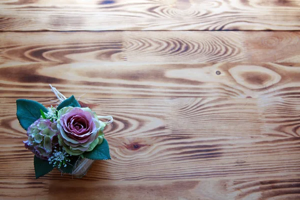 Ramo de rosas rosadas en una canasta sobre fondo marrón de madera. —  Fotos de Stock