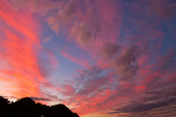 Pôr do sol dramático no céu colorido sobre a paisagem. — Fotografia de Stock