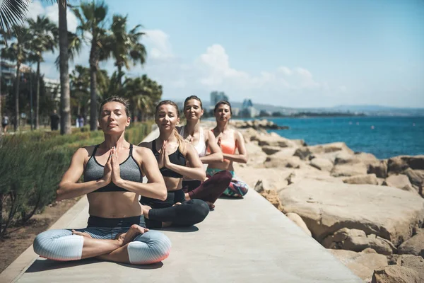Chicas ordenadas haciendo meditación en la playa — Foto de Stock