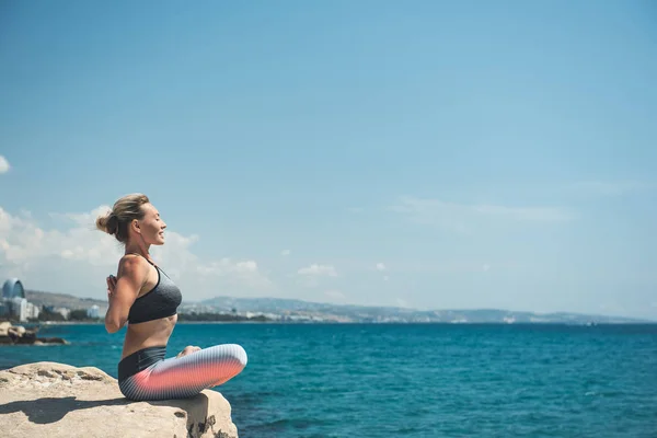Chica feliz practicando yoga cerca del mar — Foto de Stock