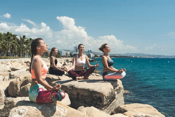 Señoras satisfechas meditando cerca del mar — Foto de Stock