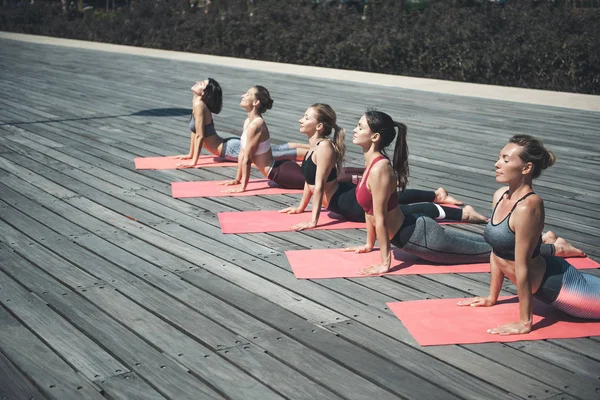 Mesdames sereines faisant du yoga dans la rue — Photo