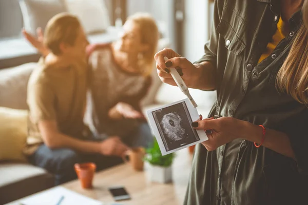 Pregnant woman showing evidence of her expectant state to couple — Stock Photo, Image