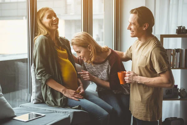 Happy future parents talking to baby inside surrogate mother belly — Stock Photo, Image