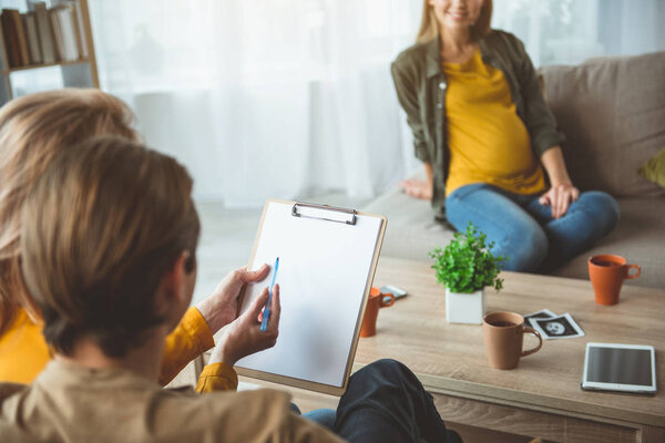 Мужчина и женщина подписывают документ о суррогатном материнстве
 