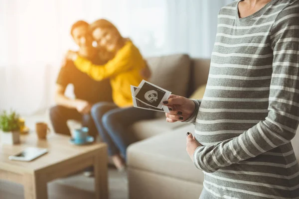 Gravid kvinna att hålla bilder av hennes ofödda barn — Stockfoto