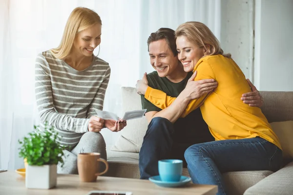 Future parents looking at fetus of surrogate mother on photo — Stock Photo, Image