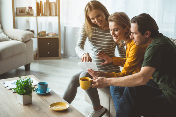 Счастливая супружеская пара смотрит на фото своего нерожденного ребенка
 