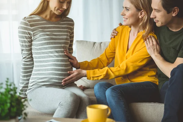 Cheerful surrogate pregnant woman gives her baby to childless family — Stock Photo, Image