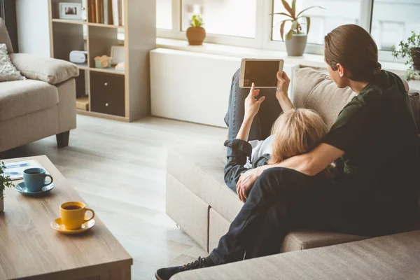 Vidám terhes nő férje dívány a pihentető — Stock Fotó