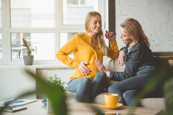 Cheerful woman supporting her pregnant sibling — Stock Photo, Image