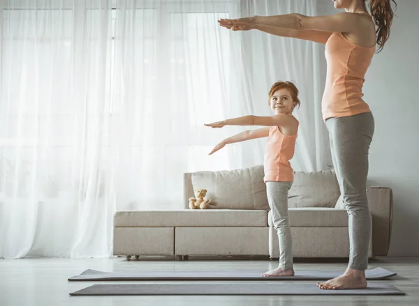 Küçük kız annesiyle evde fitness egzersiz yaparak — Stok fotoğraf