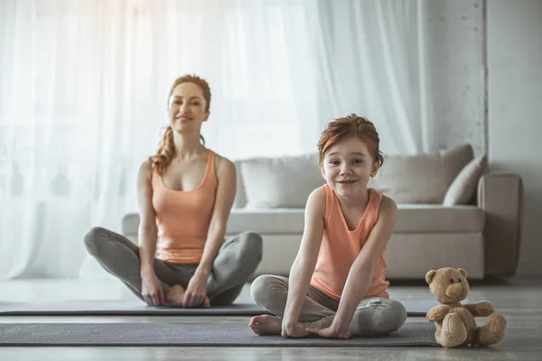 Matka a ohromen, když dítě sedí na podlaze za fitness — Stock fotografie