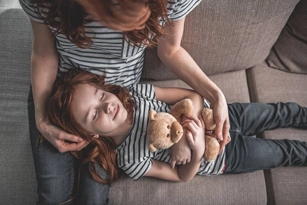 Mor med ett barn i hennes knä hemma — Stockfoto