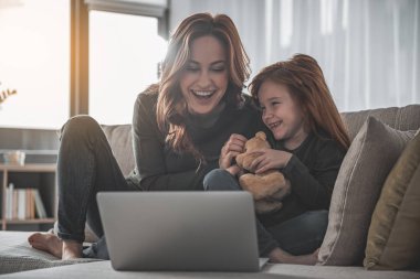Film izlerken heyecan ile gülüyor anne ve kızı