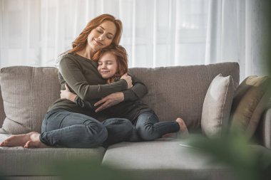 Anne ve küçük oğlunu gözleri kapalı kucaklayan