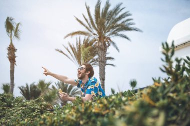 Mutlu genç adam sahne ile ilgilenen tropikal bir yerde 