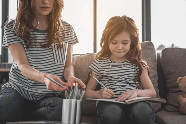 Söta fokuserad unge rita något med hennes mamma hemma — Stockfoto