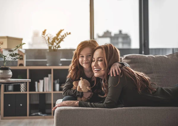 Femme et son enfant couchés sur le canapé à la maison — Photo