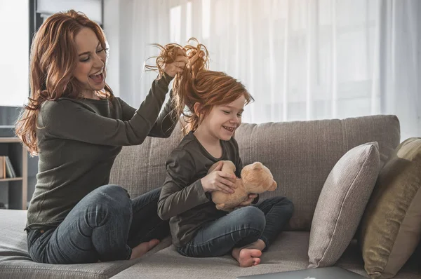 Glada kvinna leker med hennes dotter-hår hemma — Stockfoto