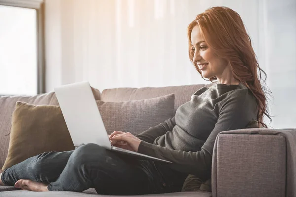 Használ a laptop otthon derűs fiatal nő — Stock Fotó