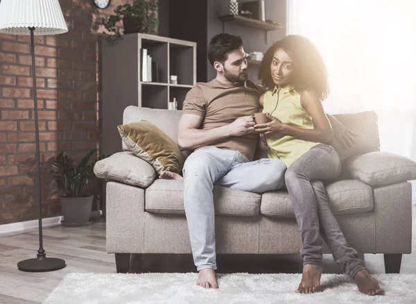 Pasangan romantis muda duduk di sofa — Stok Foto