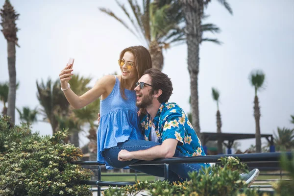 Alegre chico y chica tomando fotos en la naturaleza — Foto de Stock