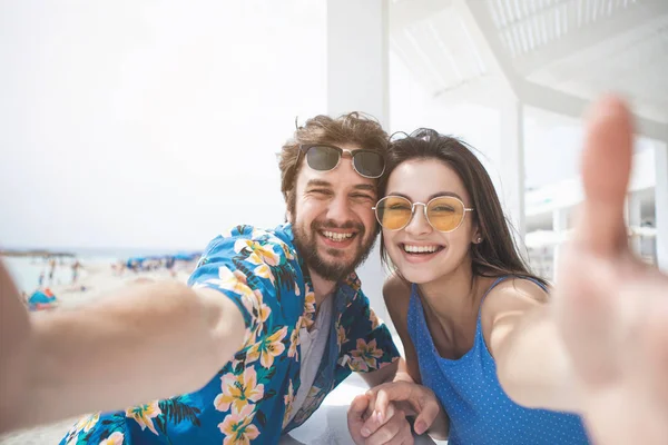 Heureux jeune homme et femme prenant des photos au bord de la mer — Photo