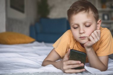 Düşünceli çocuk telefon izlerken