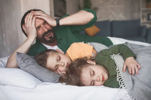 Papá triste localizando cerca de los hijos dormidos — Foto de Stock