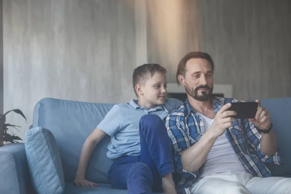 Positivo pai e filho assistindo no telefone — Fotografia de Stock