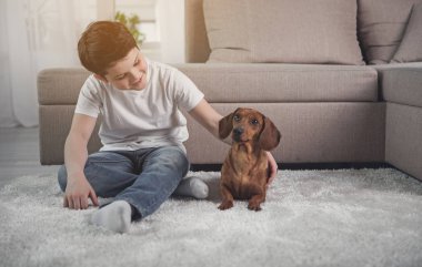 Evde köpekle oynayan mutlu çocuk
