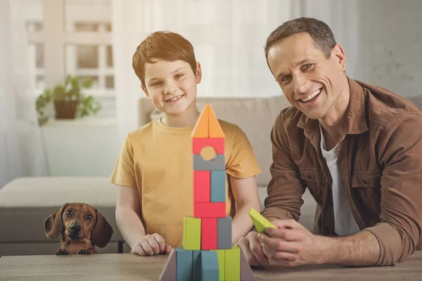 Feliz padre e hijo con cachorro jugando en casa — Foto de Stock