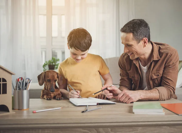 Feliz padre e hijo haciendo arte cerca del perro — Foto de Stock