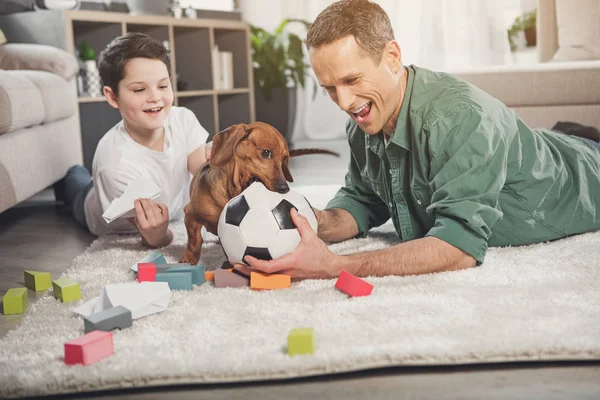 Feliz padre y niño tener divertido con cachorro — Foto de Stock