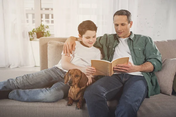 Pais alegres e criança relaxando em casa com cachorro dachshund — Fotografia de Stock