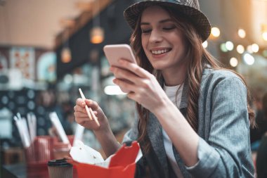 Neşeli Bayan yemek sırasında telefon kullanıyor