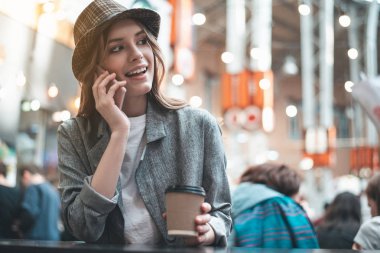 Kahve ile neşeli kadın telefonla konuşuyor