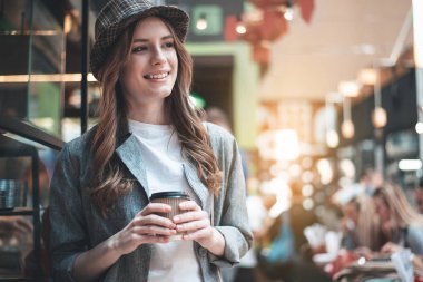 Neşeli Bayan kafede sıcak içecek keyfi