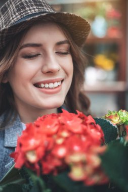 Kırmızı çiçekli neşeli genç kadın