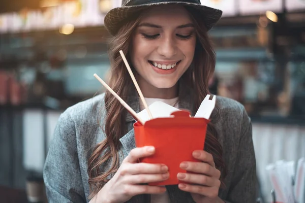 Счастливая молодая женщина с блюдом на вынос в руках — стоковое фото