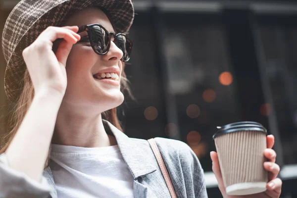 Jovencita alegre en gafas de sol con café afuera — Foto de Stock