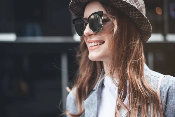 Jovencita alegre en sombrero de moda y gafas oscuras —  Fotos de Stock